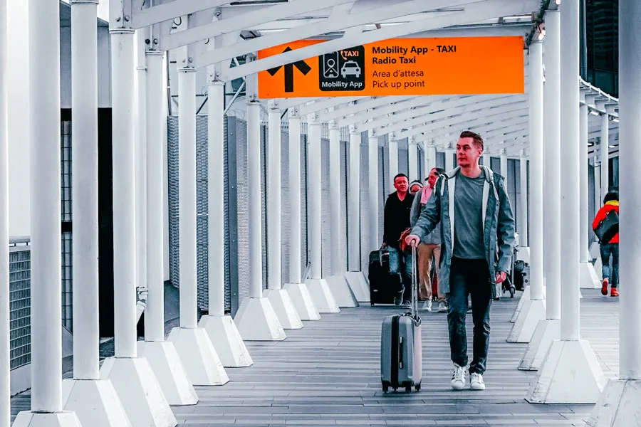 Travelers walking through an airport walkway for cross-border dental care in China - QGO Medical