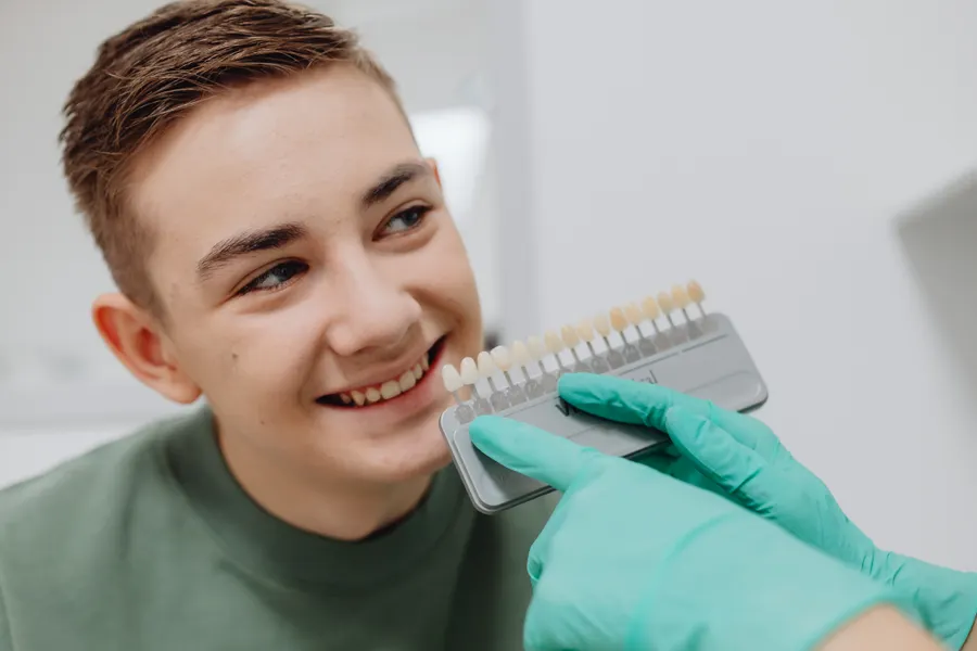 Young dental patient comparing tooth shade for bonding planning in China - QGO Medical