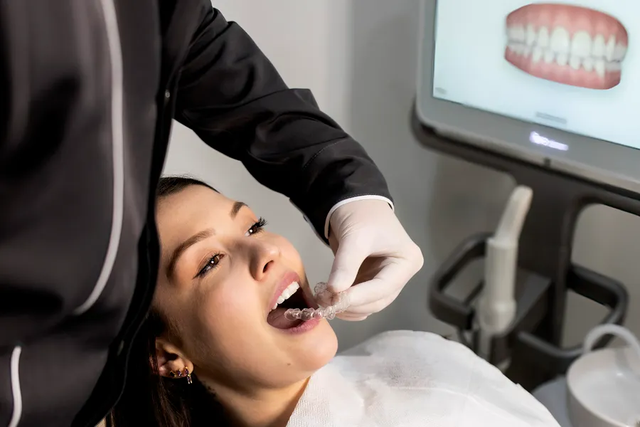 Dentist explaining dental bonding with tooth model in China - QGO Medical