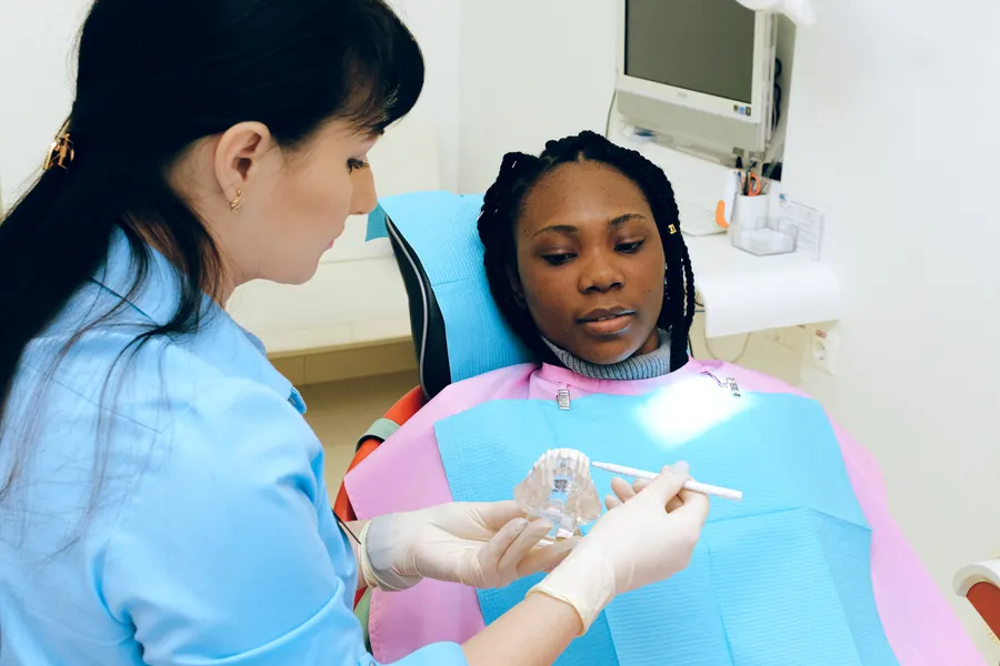 Patient checking smile in mirror after cosmetic dental consultation in China - QGO Medical
